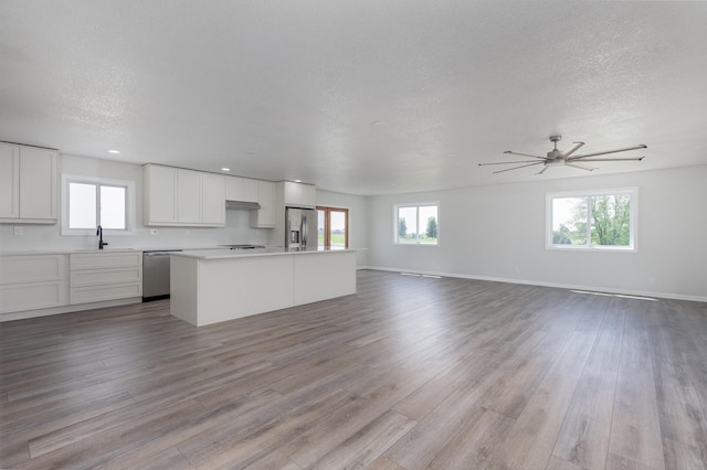 3472 N Il St Unit 23, Ottawa, IL 61350 - unfurnished living room featuring light wood-style floors, plenty of natural light, ceiling fan, a textured ceiling, and recessed lighting