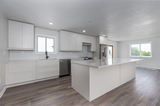 3472 N Il St Unit 23, Ottawa, IL 61350 - kitchen featuring stainless steel appliances, a textured ceiling, dark wood-style floors, under cabinet range hood, and a kitchen island