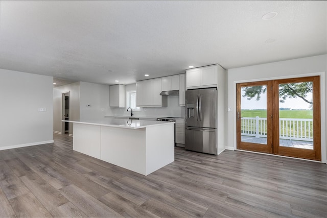 3472 N Il St Unit 23, Ottawa, IL 61350 - kitchen with stainless steel refrigerator with ice dispenser, recessed lighting, a kitchen island, wood finished floors, and under cabinet range hood