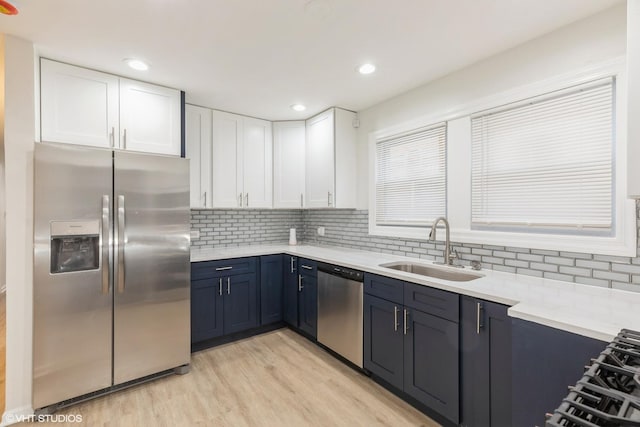 9811 S Woodlawn Ave, Chicago, IL 60628 - kitchen featuring stainless steel appliances, white cabinetry, light wood finished floors, tasteful backsplash, and recessed lighting