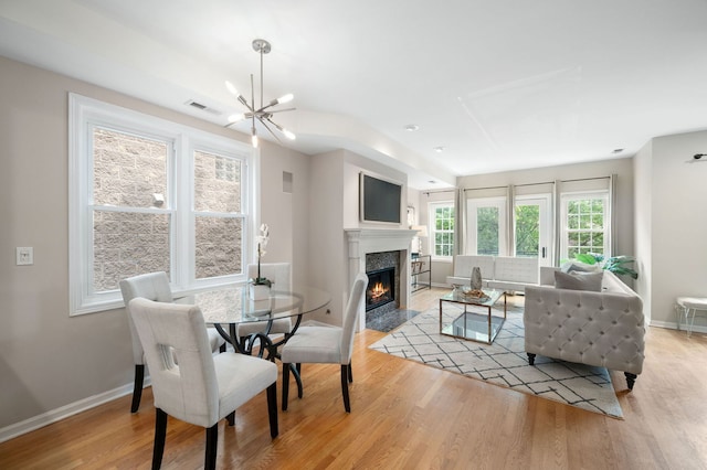 1242 W Ohio St Unit 2E, Chicago, IL 60642 - dining area featuring a chandelier, a high end fireplace, and light wood-style floors