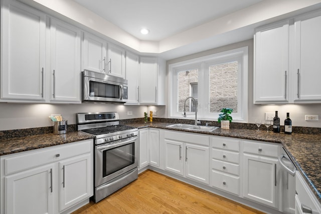1242 W Ohio St Unit 2E, Chicago, IL 60642 - kitchen featuring stainless steel appliances, white cabinetry, light wood finished floors, dark stone countertops, and recessed lighting