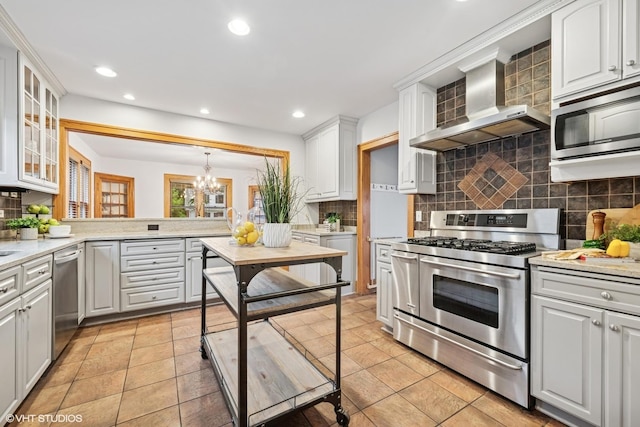 128 Coolidge Ave, Barrington, IL 60010 - kitchen with stainless steel appliances, wall chimney exhaust hood, decorative backsplash, a chandelier, and recessed lighting