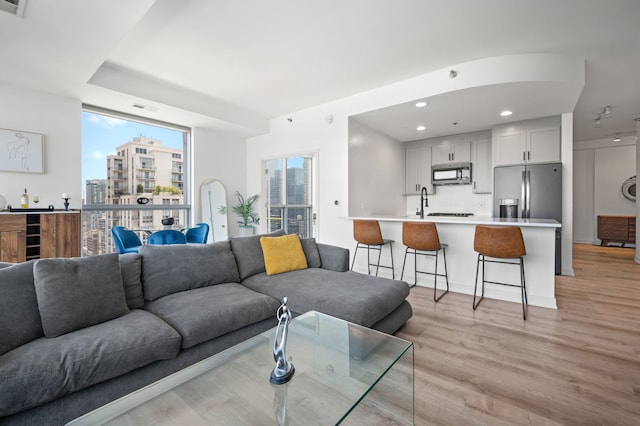 303 W Ohio St Unit 2302, Chicago, IL 60654 - living room featuring light wood-style floors, recessed lighting, a view of city, and bar