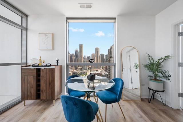 303 W Ohio St Unit 2302, Chicago, IL 60654 - dining room featuring expansive windows, wood finished floors, plenty of natural light, and a skyline view