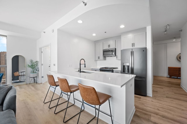 303 W Ohio St Unit 2302, Chicago, IL 60654 - kitchen with appliances with stainless steel finishes, a kitchen breakfast bar, light wood finished floors, light countertops, and recessed lighting
