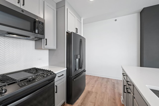 303 W Ohio St Unit 2302, Chicago, IL 60654 - kitchen with stainless steel microwave, gas stove, refrigerator with ice dispenser, tasteful backsplash, and light wood-type flooring