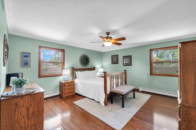 20 Park Dr, Villa Grove, IL 61956 - bedroom with a baseboard radiator, dark wood-style flooring, and ceiling fan
