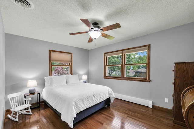 20 Park Dr, Villa Grove, IL 61956 - bedroom featuring wood finished floors, a textured ceiling, baseboard heating, and ceiling fan