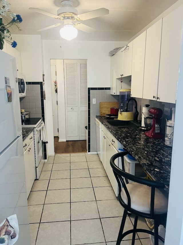 225 S Rohlwing Rd Unit 618, Palatine, IL 60074 - kitchen with white appliances, light tile patterned floors, dark countertops, and white cabinetry