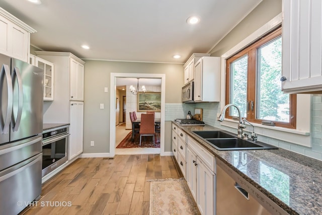 1954 Greenview St, Valparaiso, IN 46383 - kitchen featuring stainless steel appliances, a chandelier, light wood-style floors, white cabinets, and tasteful backsplash