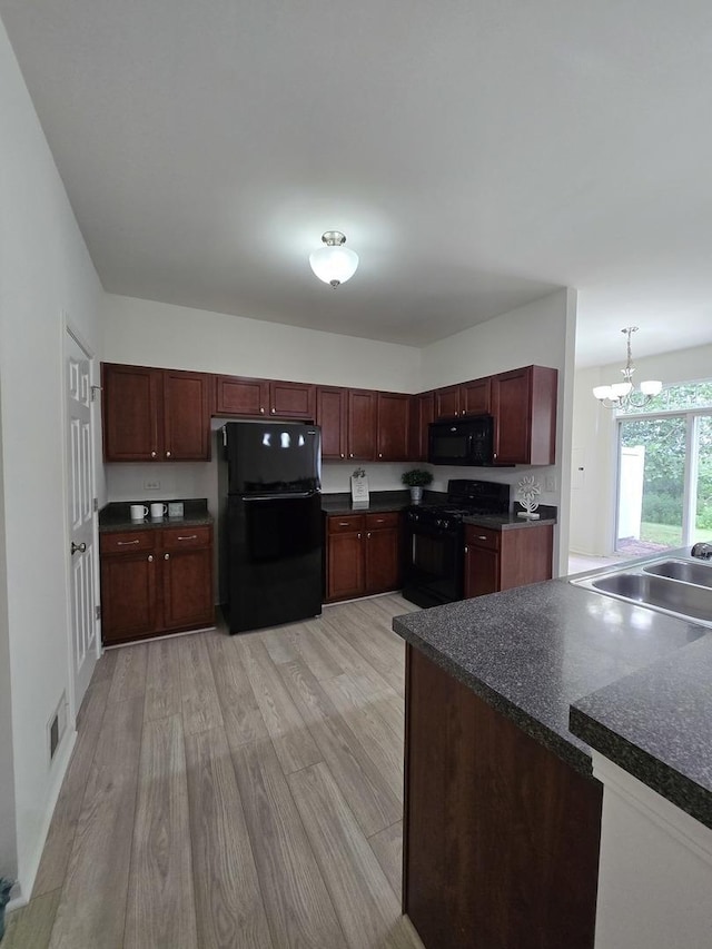 8501 Sawyer Ct, Joliet, IL 60431 - kitchen with black appliances, dark countertops, a chandelier, and light wood-type flooring