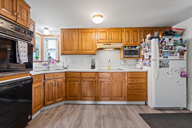 2070 County Road 2400, Thomasboro, IL 61878 - kitchen featuring black appliances, under cabinet range hood, light wood-style flooring, brown cabinets, and light countertops