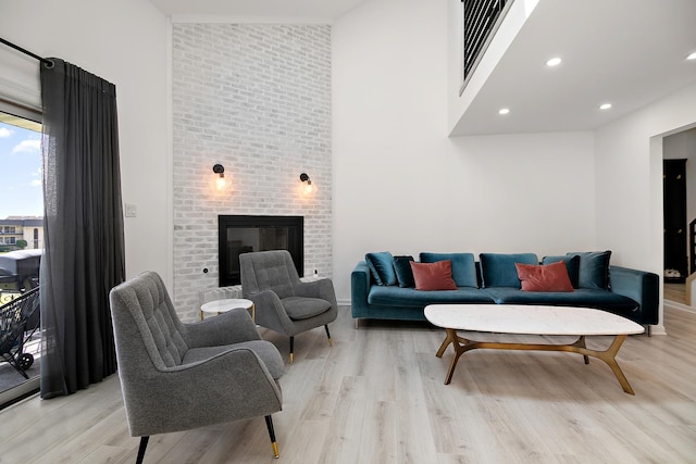 15705 Lake Hills Ct Unit 2N, Orland Park, IL 60462 - living area featuring a towering ceiling, light wood-style flooring, a brick fireplace, and recessed lighting