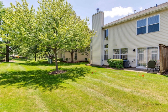 911 Waterford Ln, Elk Grove Village, IL 60007 - back of property featuring a chimney and a yard