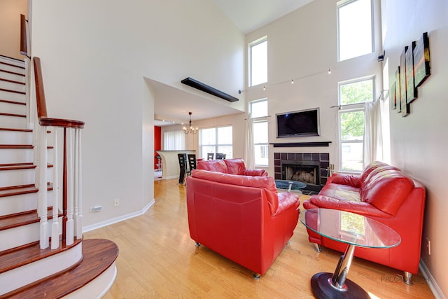 911 Waterford Ln, Elk Grove Village, IL 60007 - living room with light wood finished floors, a chandelier, stairway, a high ceiling, and a tile fireplace