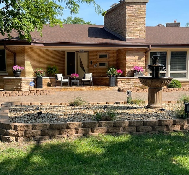 711 E Greenview Rd, Itasca, IL 60143 - rear view of house with a chimney, brick siding, a shingled roof, and a patio area