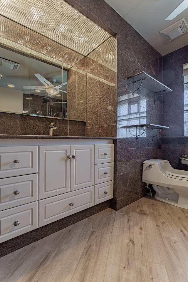 711 E Greenview Rd, Itasca, IL 60143 - bathroom with tile walls, a walk in shower, vanity, wood finished floors, and a ceiling fan