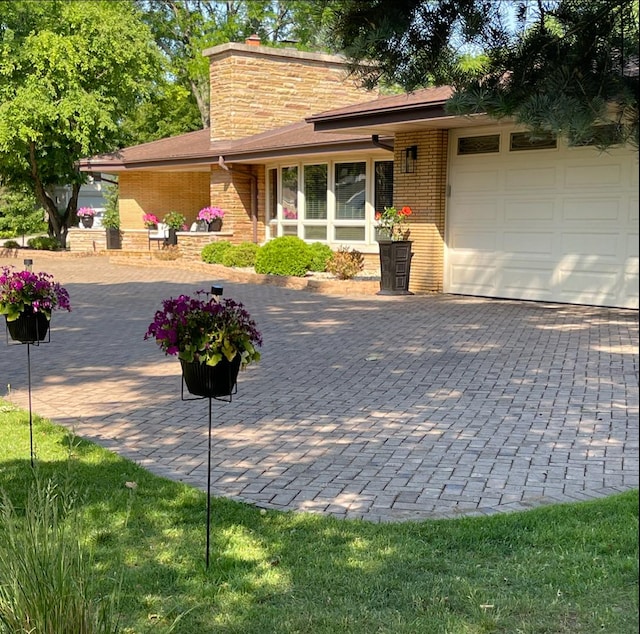 711 E Greenview Rd, Itasca, IL 60143 - view of front of property featuring an attached garage, brick siding, decorative driveway, and a chimney