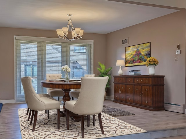 711 E Greenview Rd, Itasca, IL 60143 - dining space with a baseboard heating unit, a chandelier, and light wood-type flooring