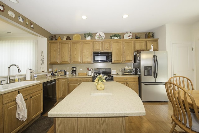 11642 Sunderlin Dr, Huntley, IL 60142 - kitchen with black appliances, wood finished floors, a kitchen island, recessed lighting, and light stone counters