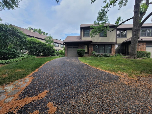 310 Partridge Ln, Wheeling, IL 60090 - view of front of home with an attached garage, brick siding, asphalt driveway, and a front yard