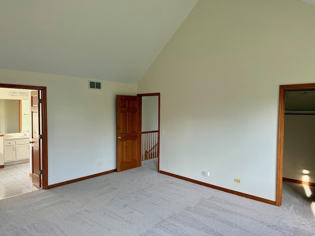 3175 Wild Meadow Ln, Aurora, IL 60504 - unfurnished bedroom featuring light carpet, a spacious closet, high vaulted ceiling, ensuite bathroom, and a closet