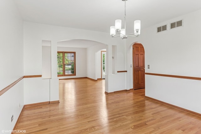 3175 Wild Meadow Ln, Aurora, IL 60504 - empty room with arched walkways, light wood-style floors, and a chandelier