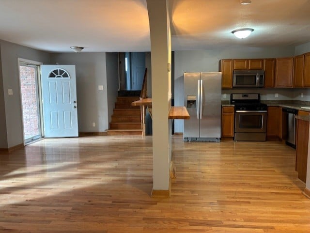 1038 Ruth Crane Dr, Rantoul, IL 61866 - kitchen featuring stainless steel appliances, brown cabinets, light wood-style flooring, and open floor plan