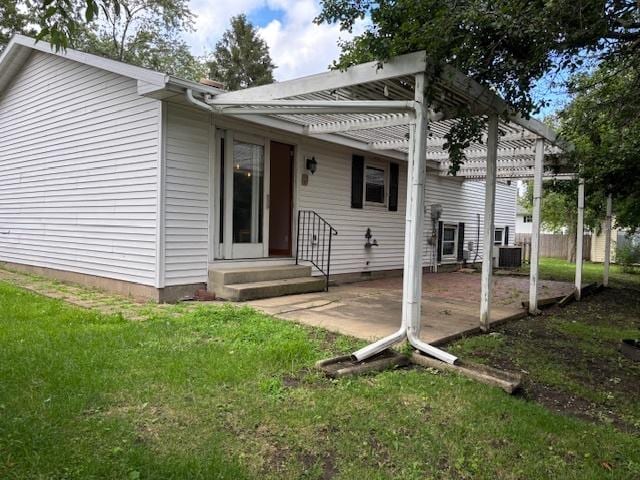 1038 Ruth Crane Dr, Rantoul, IL 61866 - back of property with entry steps, a pergola, and a yard