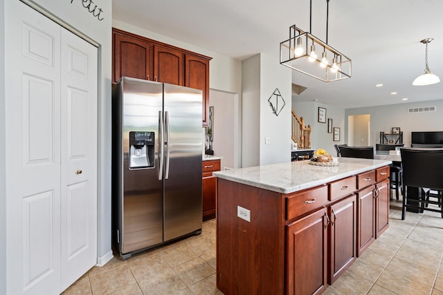 17857 Wilker Dr, Lockport, IL 60441 - kitchen featuring stainless steel refrigerator with ice dispenser, light tile patterned floors, hanging light fixtures, light stone counters, and a center island