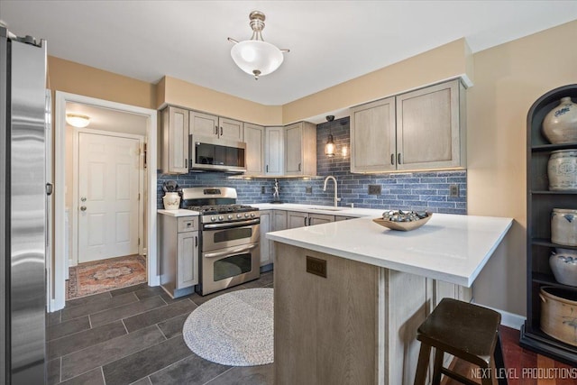 251 Abington Ln, North Aurora, IL 60542 - kitchen featuring appliances with stainless steel finishes, a breakfast bar area, a peninsula, and light countertops