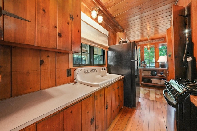 3720 E Lake Shore Dr, Wonder Lake, IL 60097 - kitchen with range with gas stovetop, wooden ceiling, freestanding refrigerator, light wood-style floors, and brown cabinetry