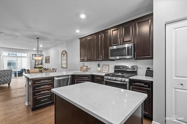 229 Lakeshore Dr, Oswego, IL 60543 - kitchen with appliances with stainless steel finishes, a peninsula, recessed lighting, dark brown cabinetry, and light stone counters