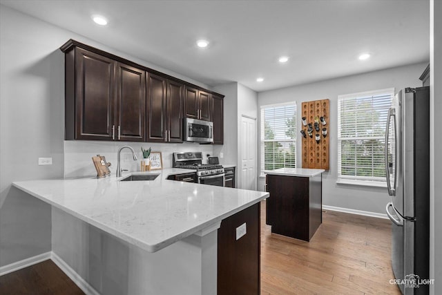 229 Lakeshore Dr, Oswego, IL 60543 - kitchen with stainless steel appliances, a center island, dark brown cabinets, wood finished floors, and recessed lighting