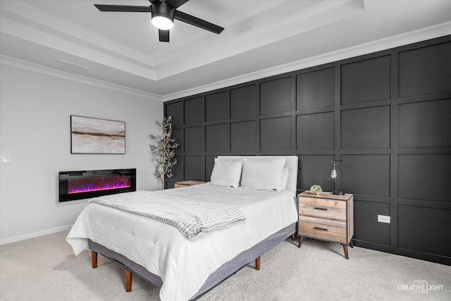 229 Lakeshore Dr, Oswego, IL 60543 - bedroom featuring a raised ceiling, a decorative wall, light colored carpet, a glass covered fireplace, and crown molding