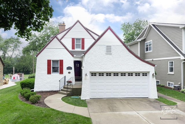 330 S Maple St, Itasca, IL 60143 - traditional-style house with a chimney, a front lawn, stucco siding, an attached garage, and driveway