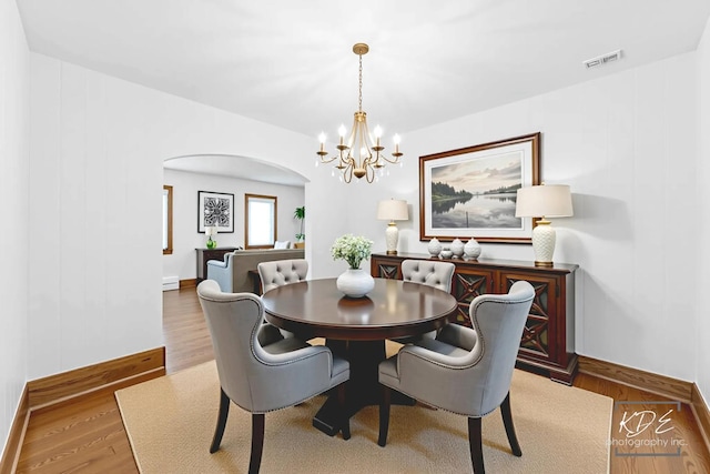 330 S Maple St, Itasca, IL 60143 - dining area with arched walkways, a chandelier, wood finished floors, and a baseboard heating unit