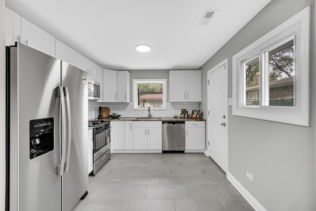 3115 172nd St, Hazel Crest, IL 60429 - kitchen featuring stainless steel appliances, decorative backsplash, white cabinetry, and dark stone countertops