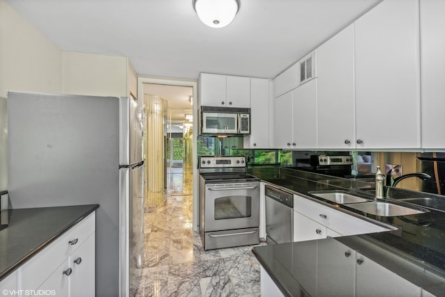 505 N Lake Shore Dr Unit 516, Chicago, IL 60611 - kitchen featuring appliances with stainless steel finishes, light marble finish floors, dark countertops, and white cabinetry
