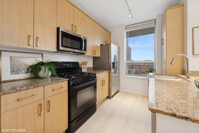330 W Grand Ave Unit 904, Chicago, IL 60654 - kitchen featuring stainless steel appliances, light brown cabinetry, light stone counters, light wood-style flooring, and track lighting