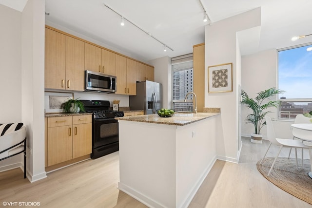 330 W Grand Ave Unit 904, Chicago, IL 60654 - kitchen featuring stainless steel appliances, light brown cabinets, track lighting, and light wood finished floors