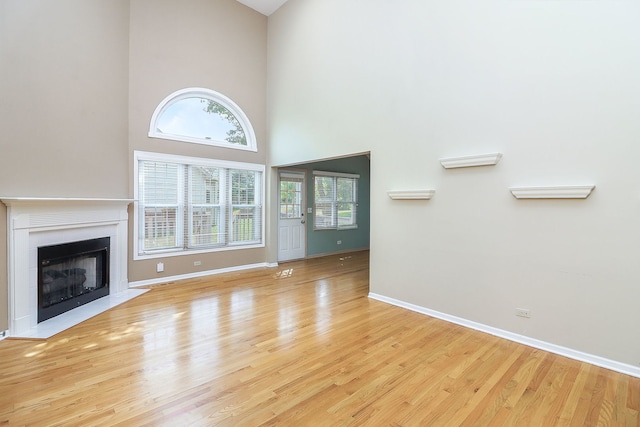 2007 Thornwood Cir, Saint Charles, IL 60174 - unfurnished living room with a towering ceiling, wood finished floors, and a fireplace with flush hearth