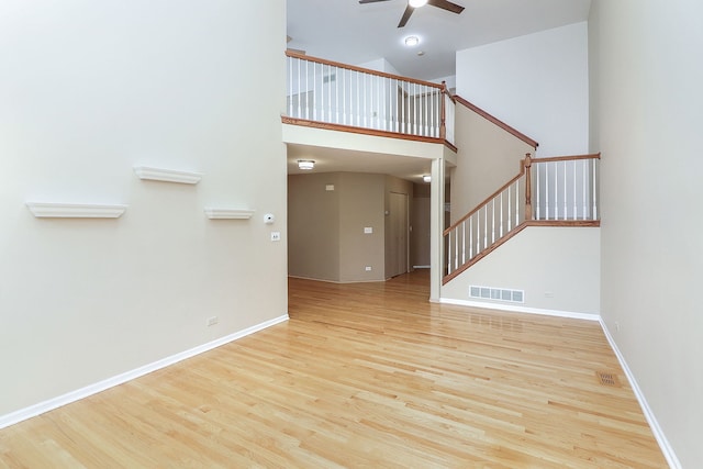 2007 Thornwood Cir, Saint Charles, IL 60174 - unfurnished living room featuring ceiling fan, wood finished floors, stairway, and a towering ceiling