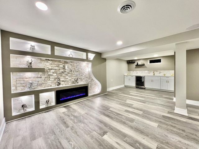 12837 S Aberdeen St, Calumet Park, IL 60827 - unfurnished living room featuring wine cooler, wet bar, light wood finished floors, recessed lighting, and a glass covered fireplace