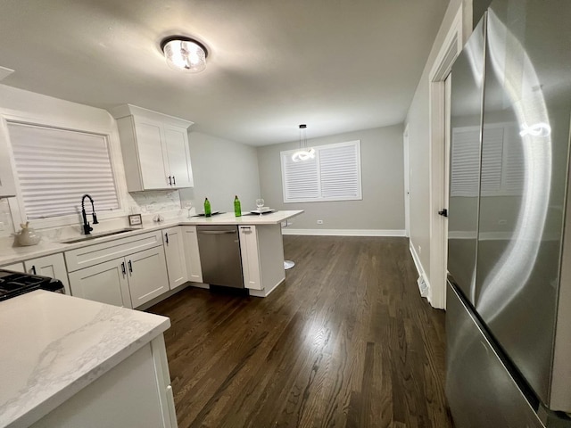 12837 S Aberdeen St, Calumet Park, IL 60827 - kitchen with stainless steel appliances, a peninsula, white cabinetry, dark wood finished floors, and hanging light fixtures