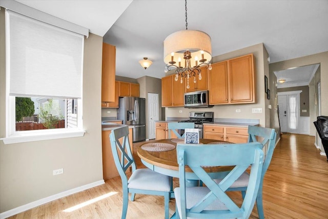 2420 Columbia Ln, Montgomery, IL 60538 - kitchen with stainless steel appliances, light wood-type flooring, a chandelier, hanging light fixtures, and light countertops