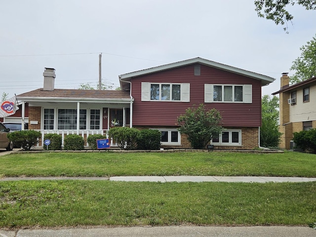 172 N Floyd Ln, Chicago Heights, IL 60411 - tri-level home with a front lawn, brick siding, and a chimney