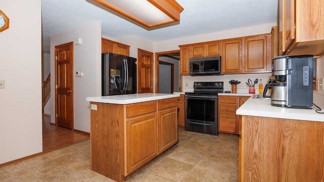 410 Wildberry Dr, Normal, IL 61761 - kitchen featuring black appliances, brown cabinetry, light countertops, and a kitchen island