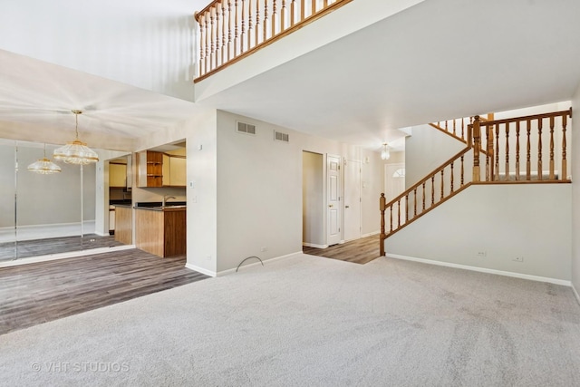 614 Hillview Ct, West Chicago, IL 60185 - unfurnished living room with carpet, stairway, and a chandelier